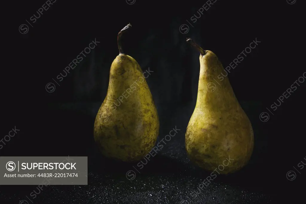 Two pears over wet black background