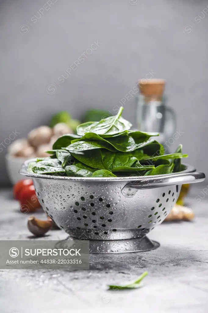 Spinach. Fresh organic spinach leaves in metal colander and healthy ingredients. Diet, dieting concept. Vegan food, healthy eating.