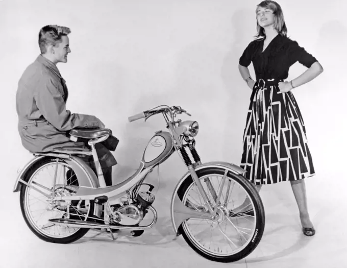 Teenagers of the 1950s. A teenage boy and girl with a brand new Monark moped. Sweden 1950s.