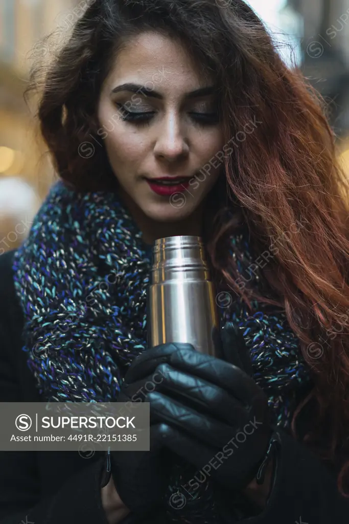 Woman with thermos on street