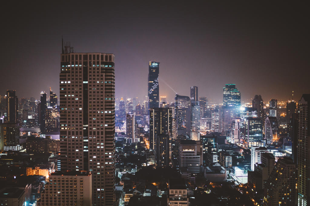 Cityscape of Bangkok with bright burning skyscrapers in night time, Thailand
