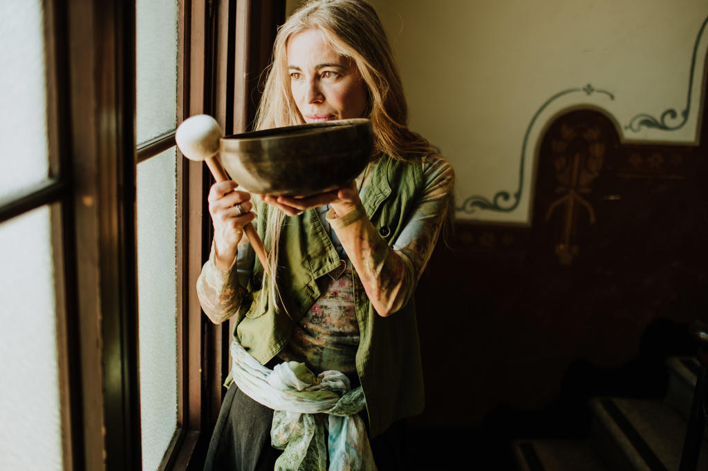 Woman playing tibetan bowls at home