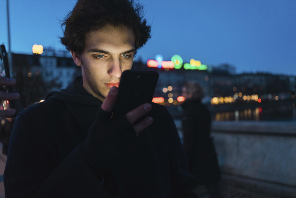 Man browsing smartphone in evening