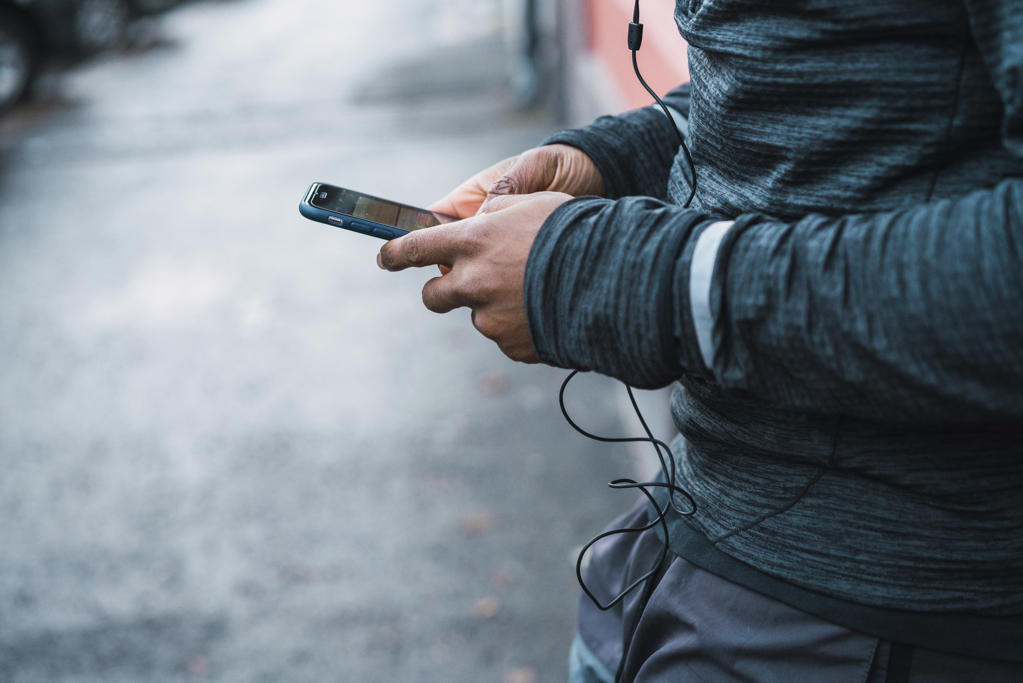 Sportive man with smartphone and listening music