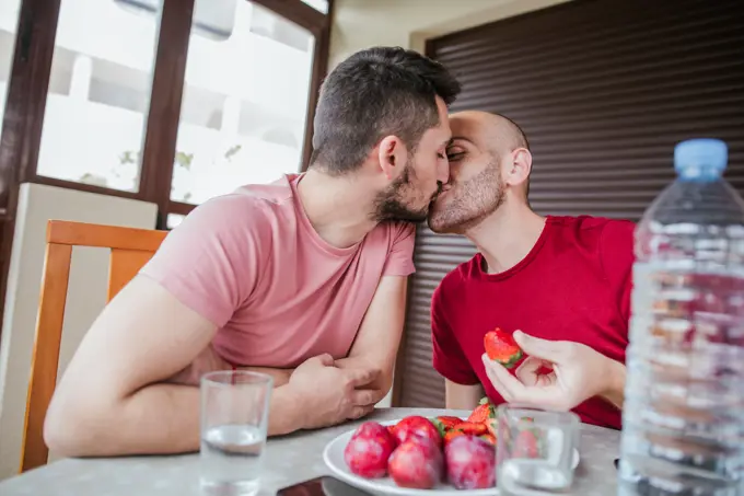 Gay couple eating strawberries