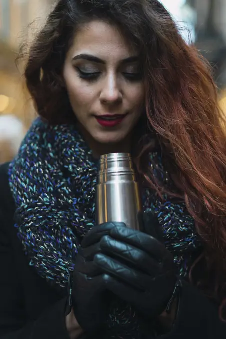 Woman with thermos on street