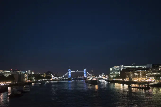 View of beautiful cityscape of London with glowing lights taken from river.