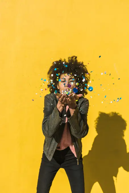 Black woman with afro hair throwing confetti to celebrate a very special day