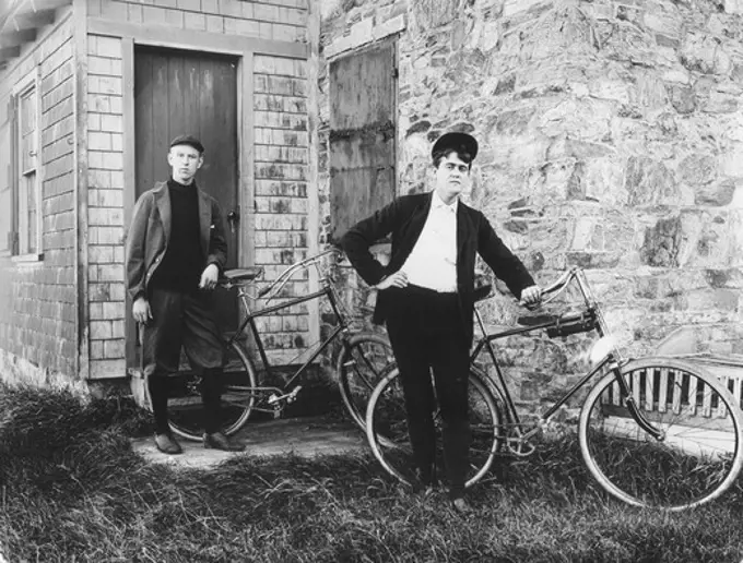 two men posing bicycles
