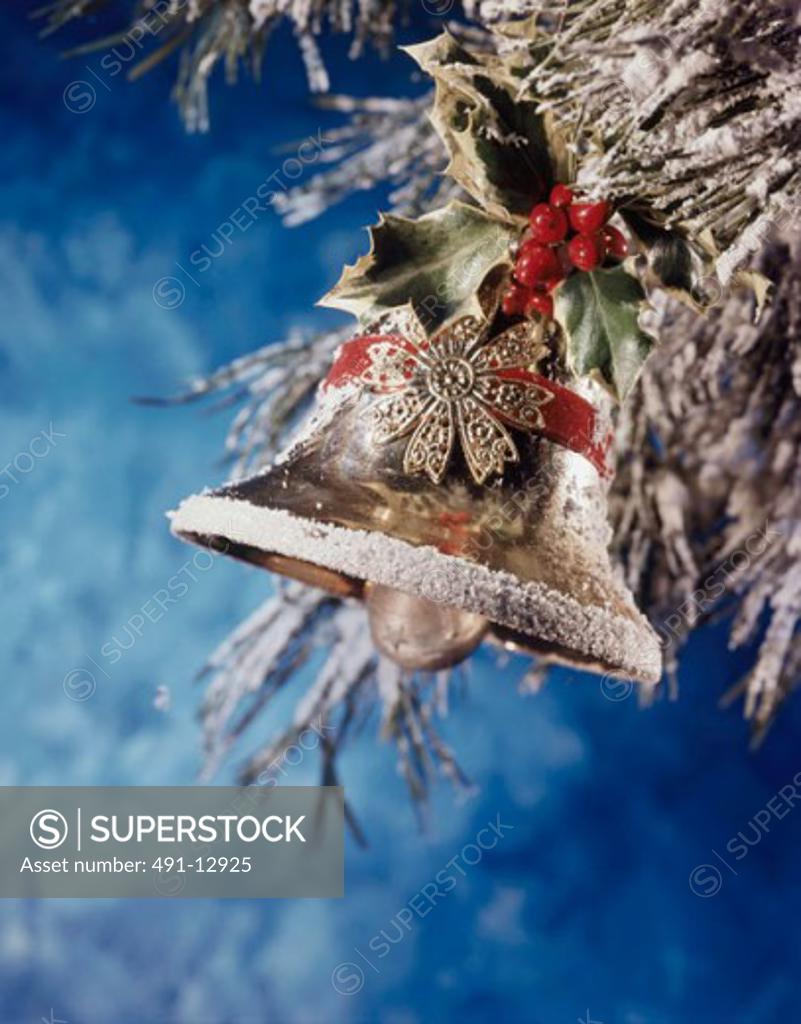 Stock Photo: 491-12925 Close-up of a bell with holly leaves and berries hanging on a Christmas tree