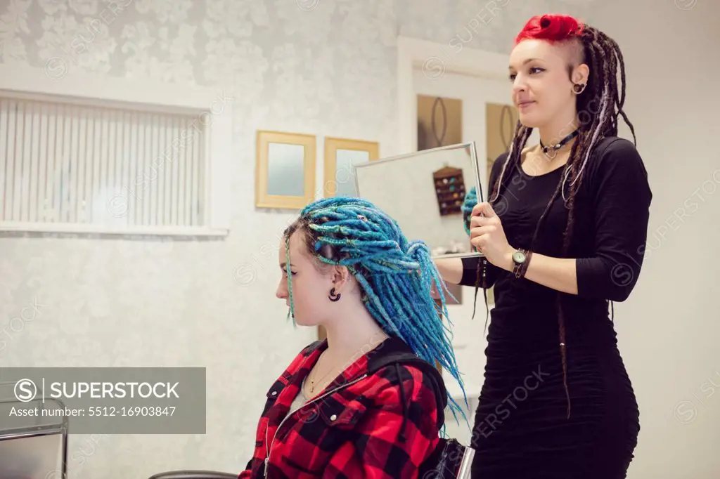 Beautician styling clients hair in dreadlocks shop