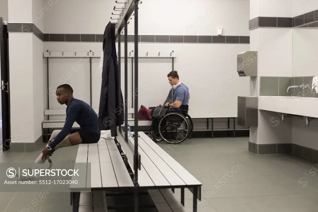 Two disabled athletics relaxing together in changing room