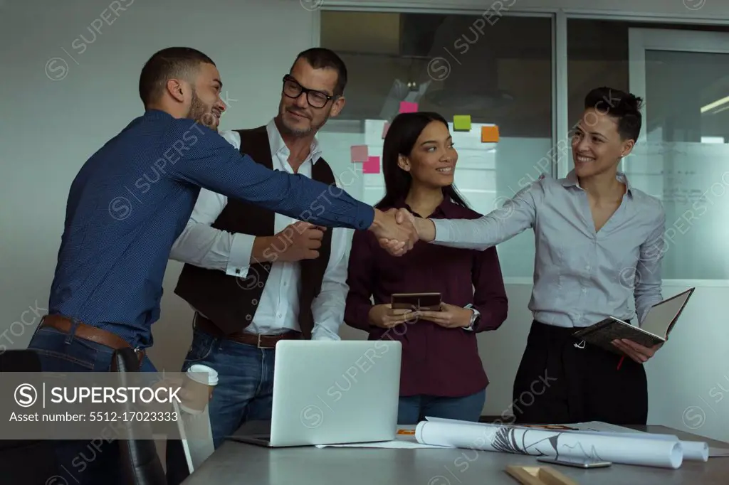 Smiling executives interacting with each other in office