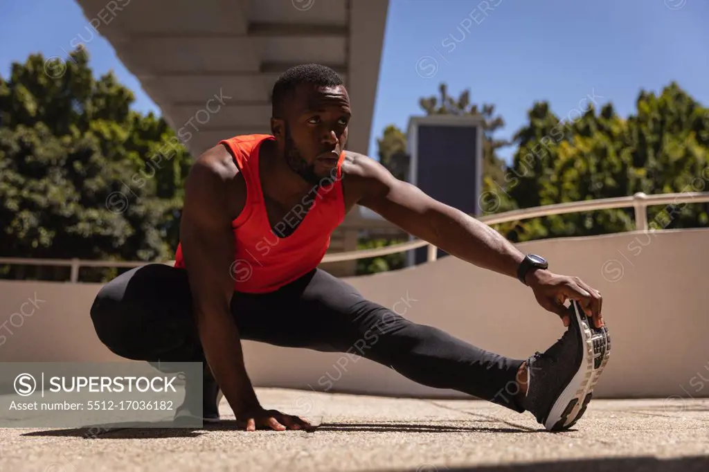 Front view of young man doing exercise under the bridge on a sunny day