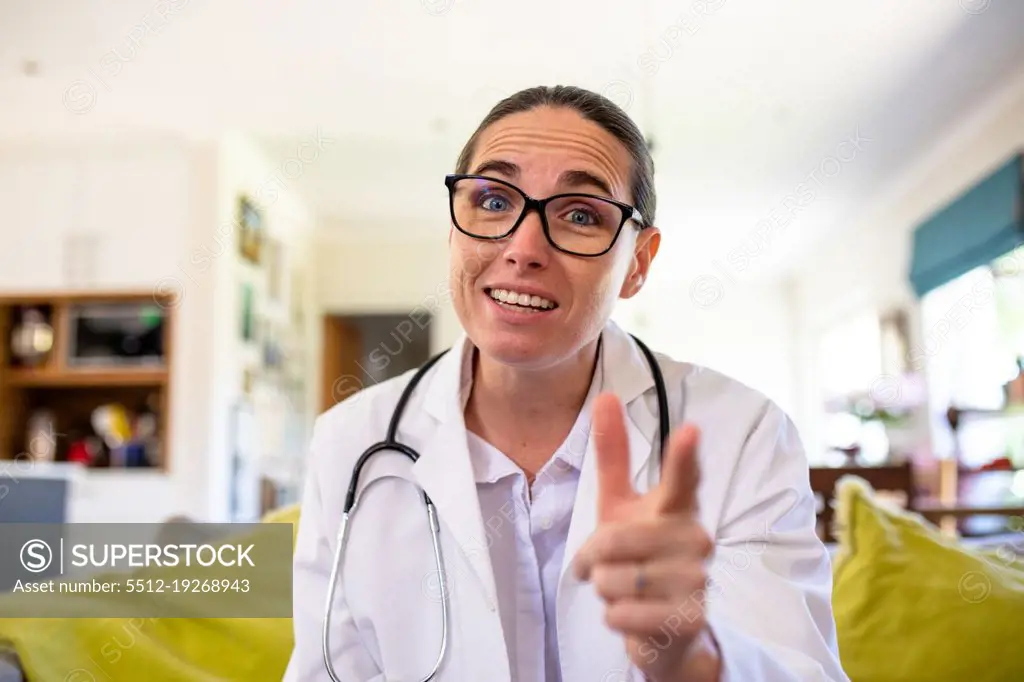 Mature caucasian female doctor gesturing while explaining on video call, copy space. unaltered, telemedicine and healthcare concept.