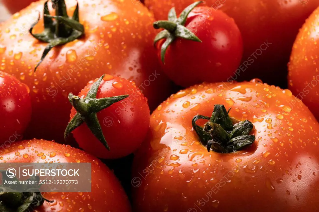 Full frame shot of water drops on fresh red tomatoes. unaltered, organic food and healthy eating concept.