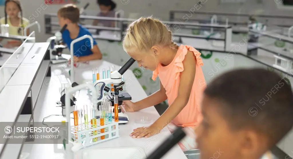 Multiracial elementary students looking through microscope during science class. unaltered, education, childhood, learning, science, stem, chemical and school concept.