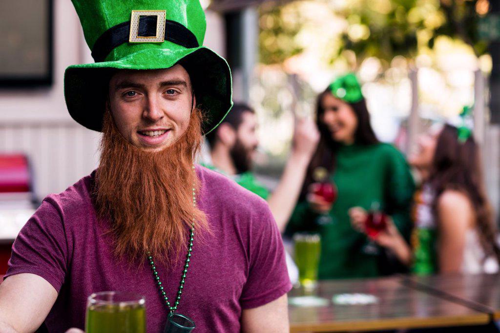 Portrait of man celebrating St Patricks day with a green pint