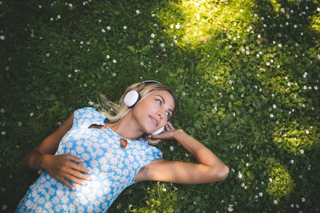 Beautiful woman listening music in garden