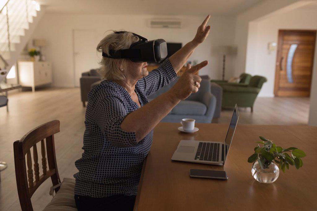 Side view of senior woman using virtual reality headset at home