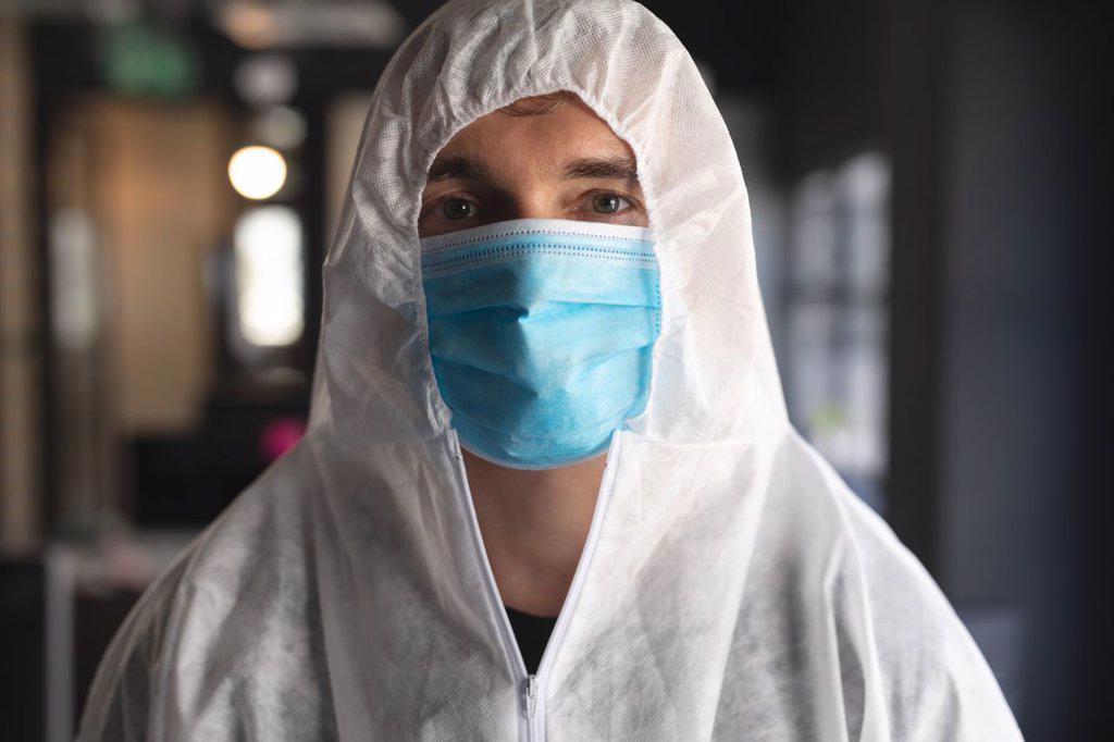Portrait of male health worker wearing face mask and protective clothes at modern office. cleaning and disinfection prevention and control of covid-19 epidemic