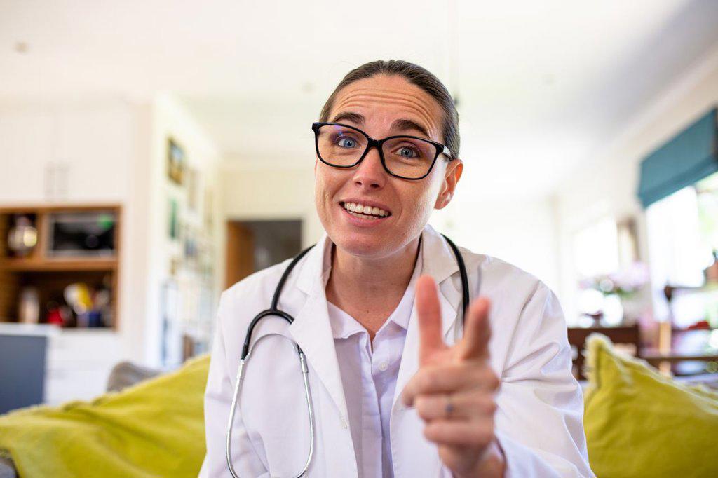 Mature caucasian female doctor gesturing while explaining on video call, copy space. unaltered, telemedicine and healthcare concept.