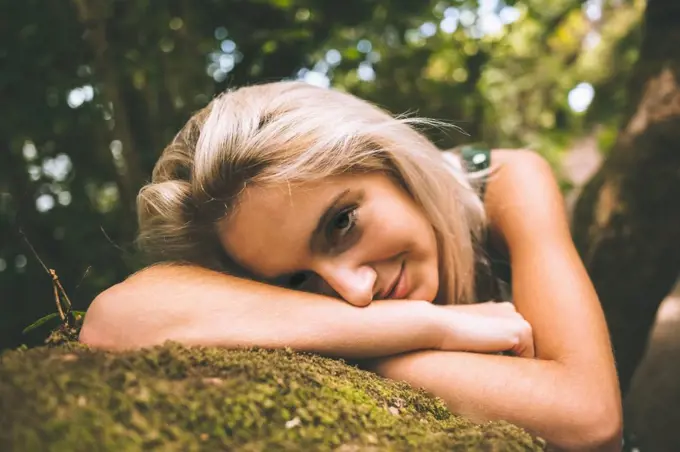 Content gorgeous blonde lying on trunk in the woods