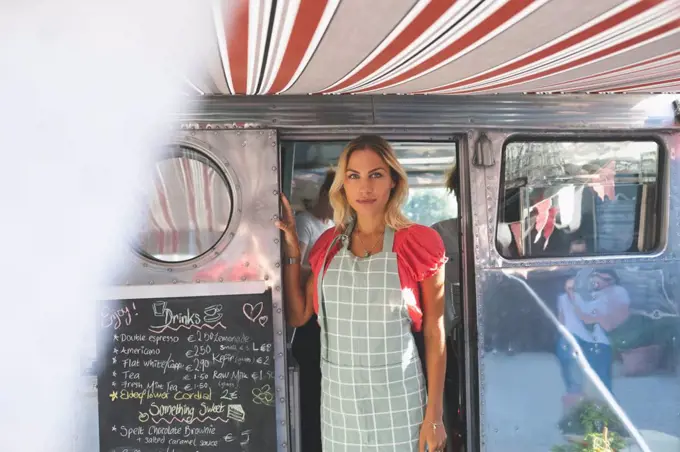Beautiful female waitress standing in food truck