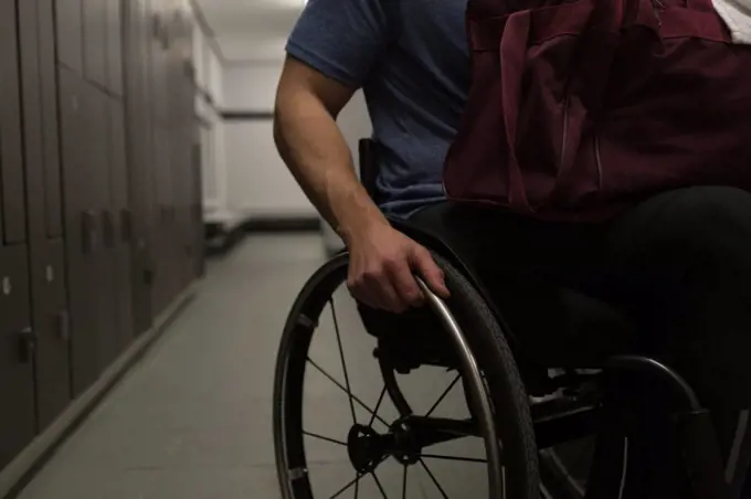 Mid section of disabled man with his bag in locker room