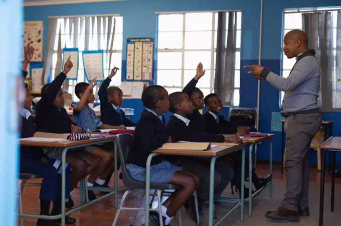 Male teacher teaching students in the classroom at school