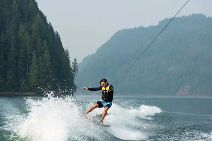 Young man wakeboarding in the river