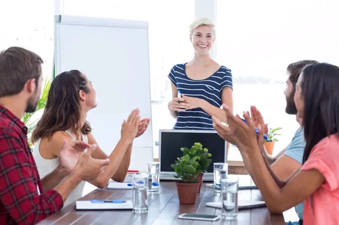Young business team clapping hands in a meeting