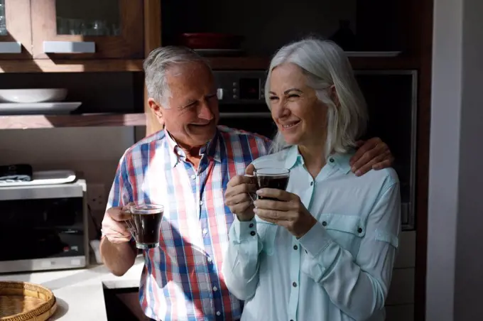 Senior caucasian couple drinking coffee together in the kitchen at home. social distancing quarantine lockdown during coronavirus pandemic