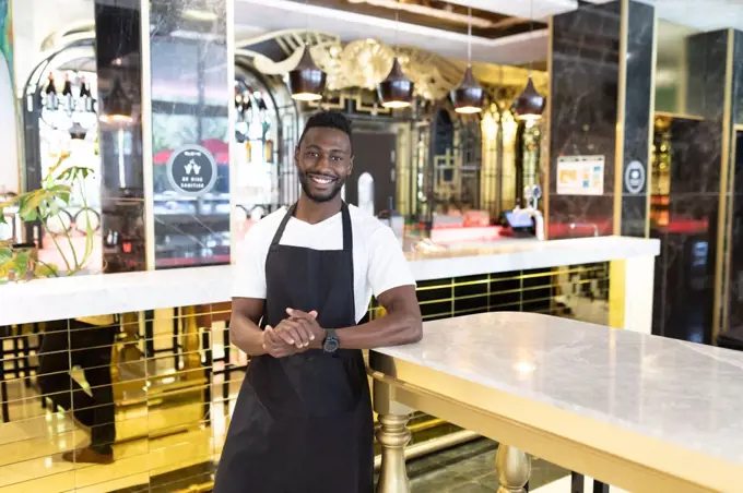 Portrait of african american male barista looking at the camera and smiling. independent small business owner.