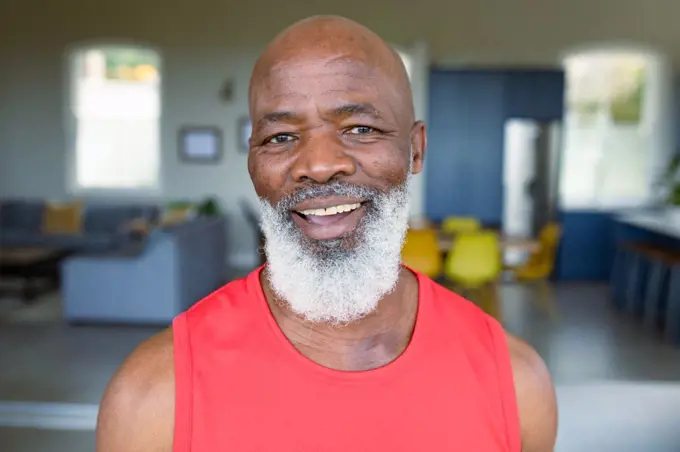 Portrait of happy senior african american man in exercise clothes looking at camera and smiling. healthy, active retirement lifestyle at home.