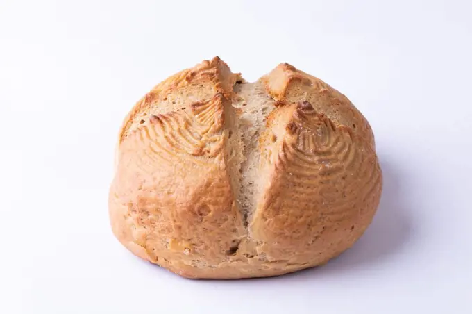 Close-up of cross bun against white background. unaltered, healthy food, cross shape, textured and baked food.