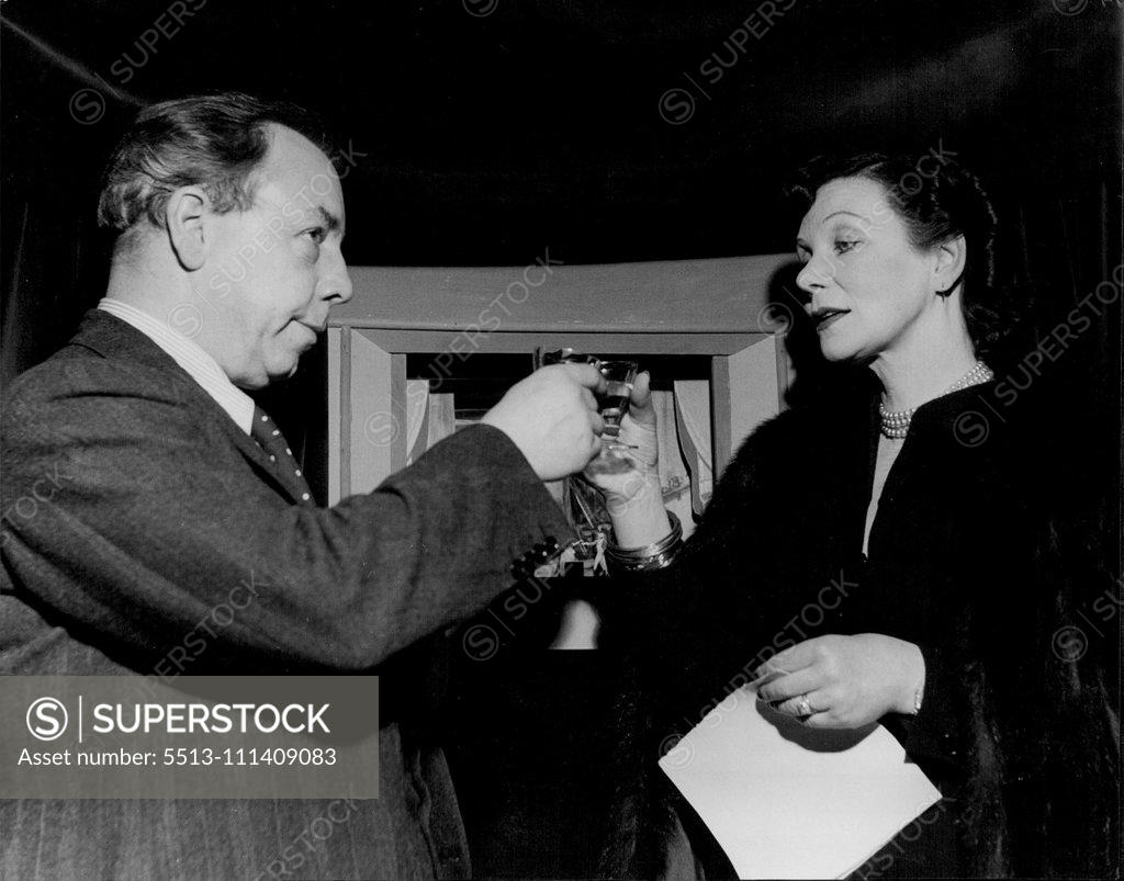 Stock Photo: 5513-111409083 J.B. Priestley's "High Toby" -- A toast to the Toy Theatre : Mr. Priestley clinks glasses with Miss Doris Zinkeisen the famous London stage designer who was responsible for the charming sets of the little stage. April 11, 1949. (Photo by Tom L. Blau, Camera Press).