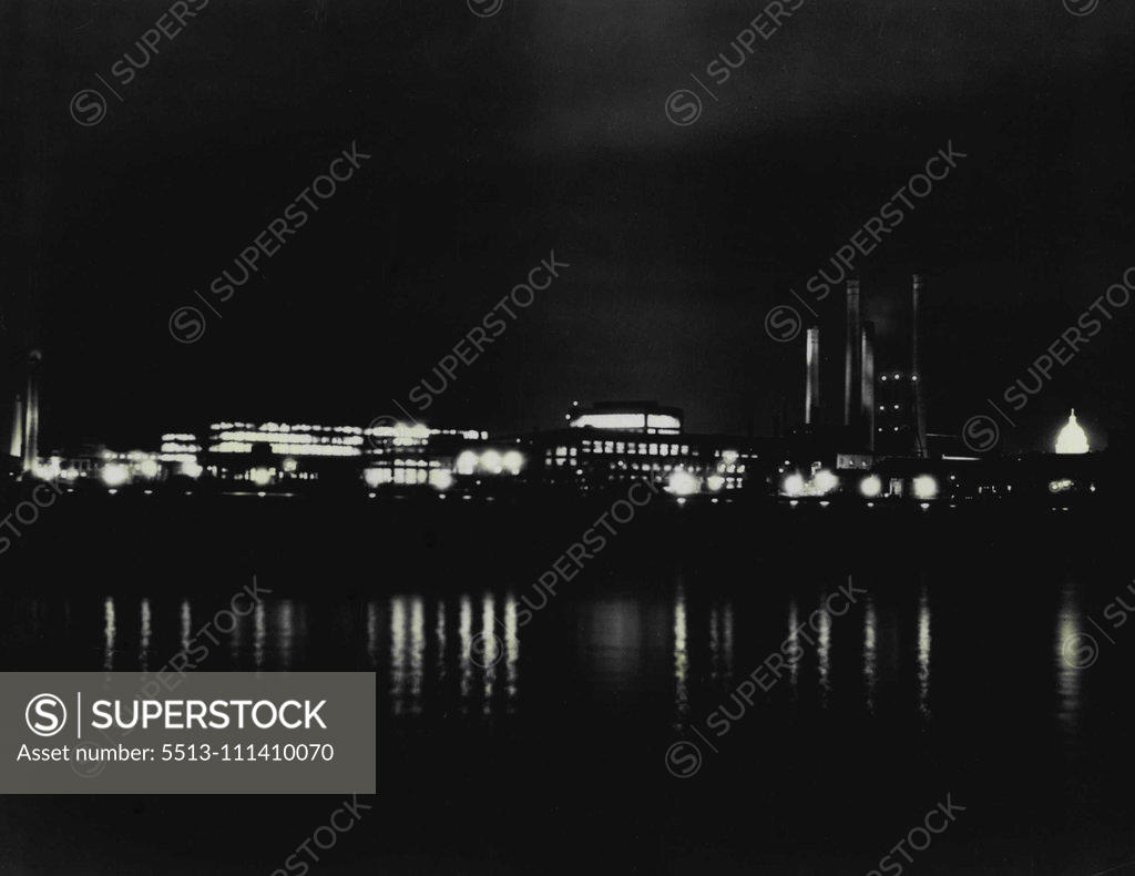 Stock Photo: 5513-111410070 Lights Burn Late In Navy's Busy Gun Factory -- An unusual night picture of the Navy yard at Washington D.C., its lights reflected in the Anacosta River near its junction with the Potomac, where approximately 8,000 men are employed now in day and night shifts making guns for the new cruisers and destroyers financed from public works funds. Repairing of the heavy guns of older ships and the manufacture of other Naval equipment goes on as usual. Not since 191 has the yard been the scene of so much 