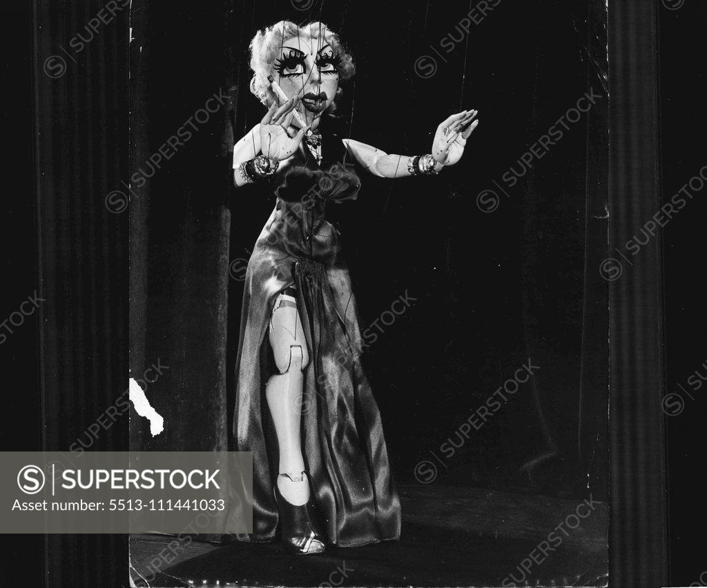 Stock Photo: 5513-111441033 Marionette Goes Burlesque -- The burlesque act if Stripsy Roselie, that most unusual and strikingly lifelike marionette, designed by famous pupeteers Walton and O'Rourke, is the sensation of Los Angeles night clubs. Stripsy entering the stage for her strip tease. Her music is "My Heart Belongs to Daddy," which she sings as she does her dance routine and strip tease. Notice her cigarette; she exhales talcum powder for smoke. May 20, 1939. (Photo by Boros-Pix).