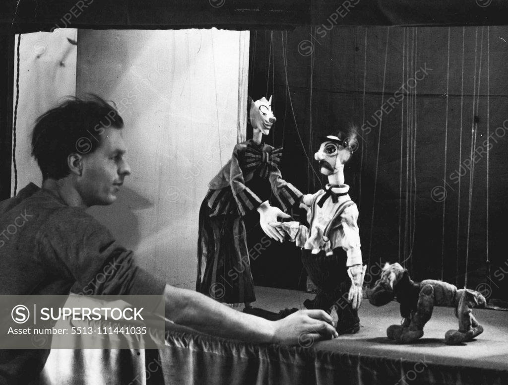 Stock Photo: 5513-111441035 Marionette Show -- Mr. Kenneth Wood arranging his own models ready for the show. An exhibition of Marionettes was opened today (Wed) at the Wertheim Gallery W. when a show was given. December 28, 1937. (Photo by L.N.A.).