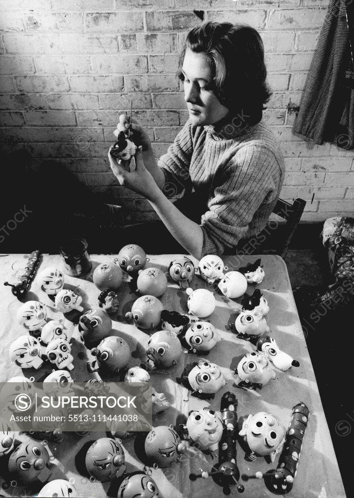 Stock Photo: 5513-111441038 She Paints Puppet Faces -- Painting faces on the wooden heads of puppets is Jean Harley, who work in a most unusual factory in the Wiltshire market town of Marlborough. Here, at the only factory of its king in England, a group of enthusiastic workers produce the Pelham hand-made puppets which, in the past five years, have found their way into almost every country in the world. Some of them are familiar to television viewers. October 22, 1952. (Photo by Reuterphoto).