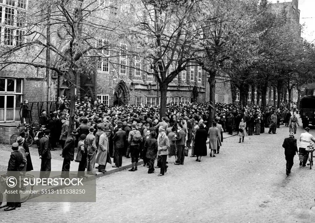 Now they're free to go to work: Changing Wehrmacht grey uniforms for worn civilian dress, more and more German men are receiving the civilian papers releasing them from the army and freeing them for employment. Here a crowd of ex-soldiers gather outside the army release centre in Luneburg. November 11, 1945. (Photo by Mirror Features).