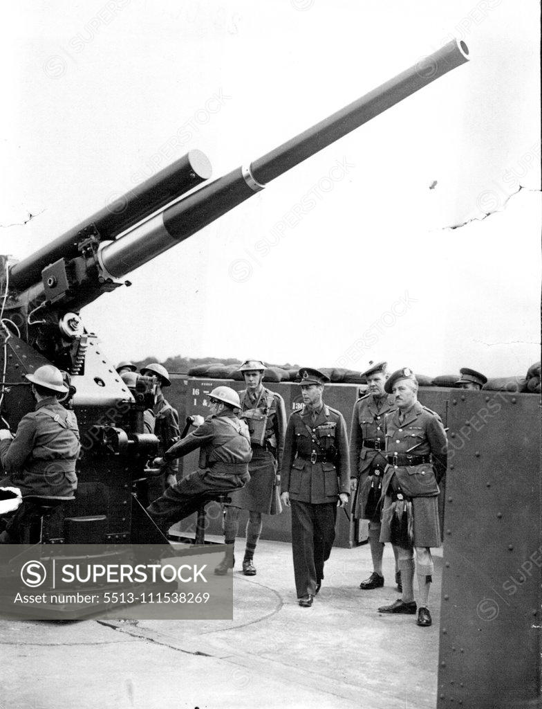 Stock Photo: 5513-111538269 King Visits Anti-Aircraft Unit: Accompanied by seven staff officers, the King made a tour of inspection of three anti-aircraft and search light sites in parts of Kent, on arrival by car he shook hands with the officers, inspected the crews, and visited the huts and pits. H.M. The King inspecting an anti-aircraft gun during his tour. August 14, 1940. (Photo by Sport & General Press Agency, Limited).