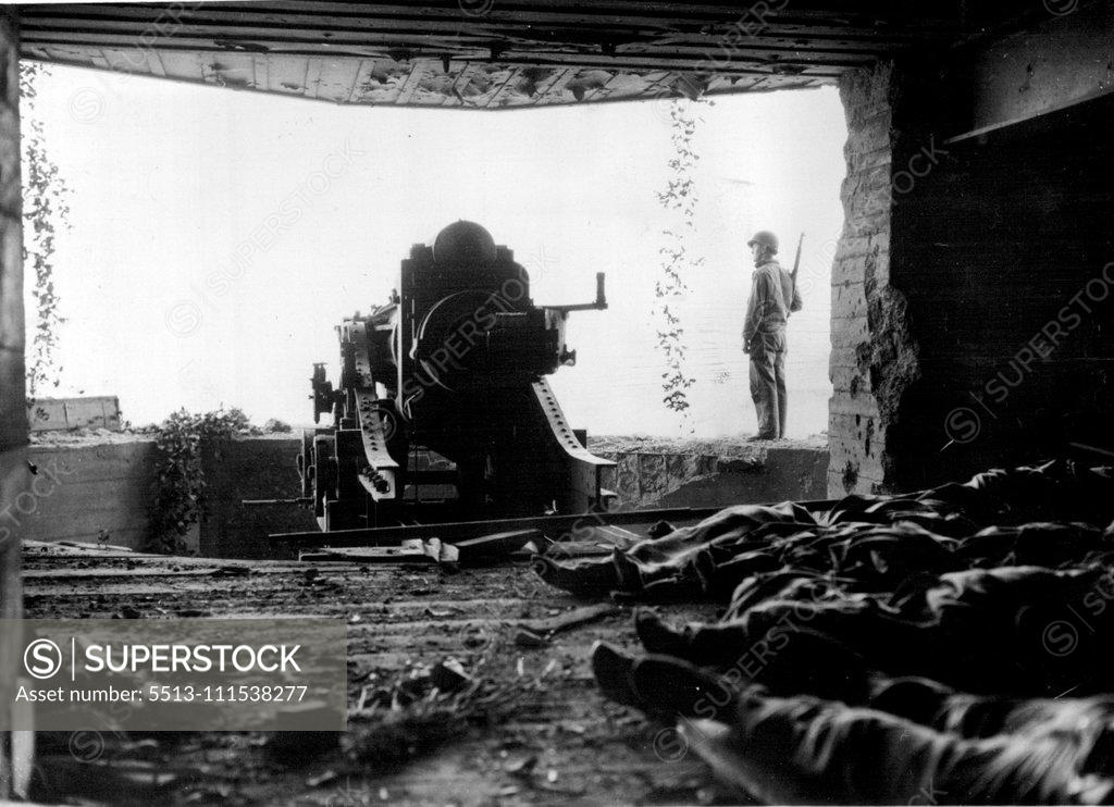 Stock Photo: 5513-111538277 A Crack in the West Wall: A view from the interior of a large German coast defense gun with its dead crew. They and the gun were knocked out by artillery fire and naval guns during the American advance across the Cherbourg Peninsula. August 1, 1945. (Photo by Associated Press Photo).