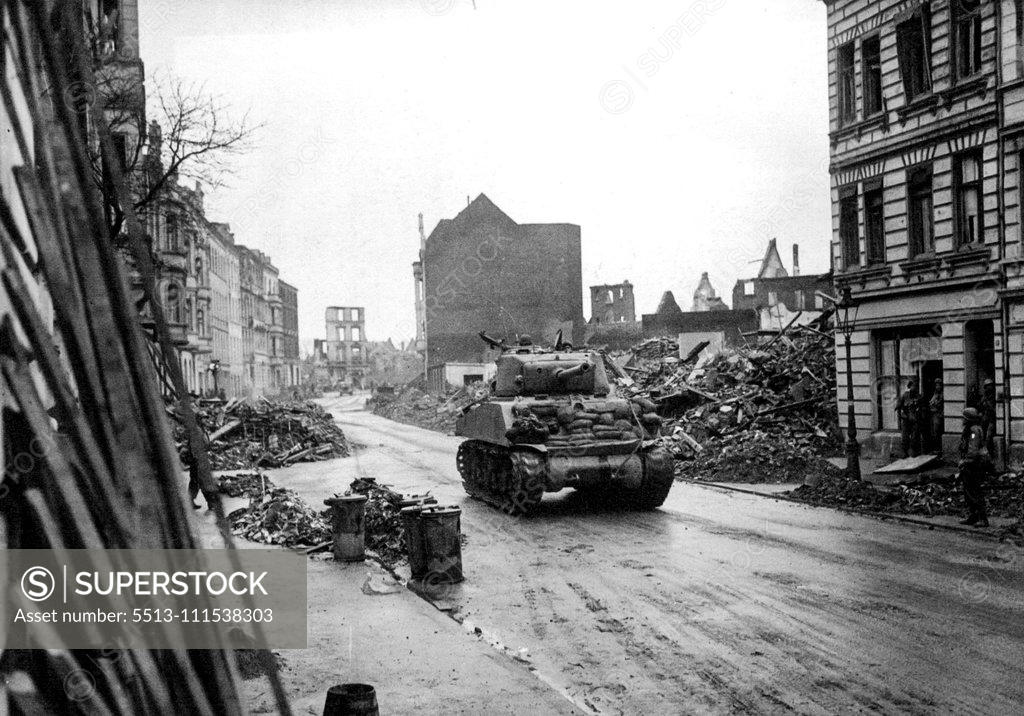 Stock Photo: 5513-111538303 Cologne - Ground Pictures: An American tank rambled through a wreckage-lined street in the outskirts of Cologne. A R.A.F. official photographer entered Cologne with American troops today and secured there pictures - the first ground pictures. They show some of the effects of the terrific air bombardment of this key Rhine city. March 7, 1945. (Photo by The Topical Press Agency Ltd.).
