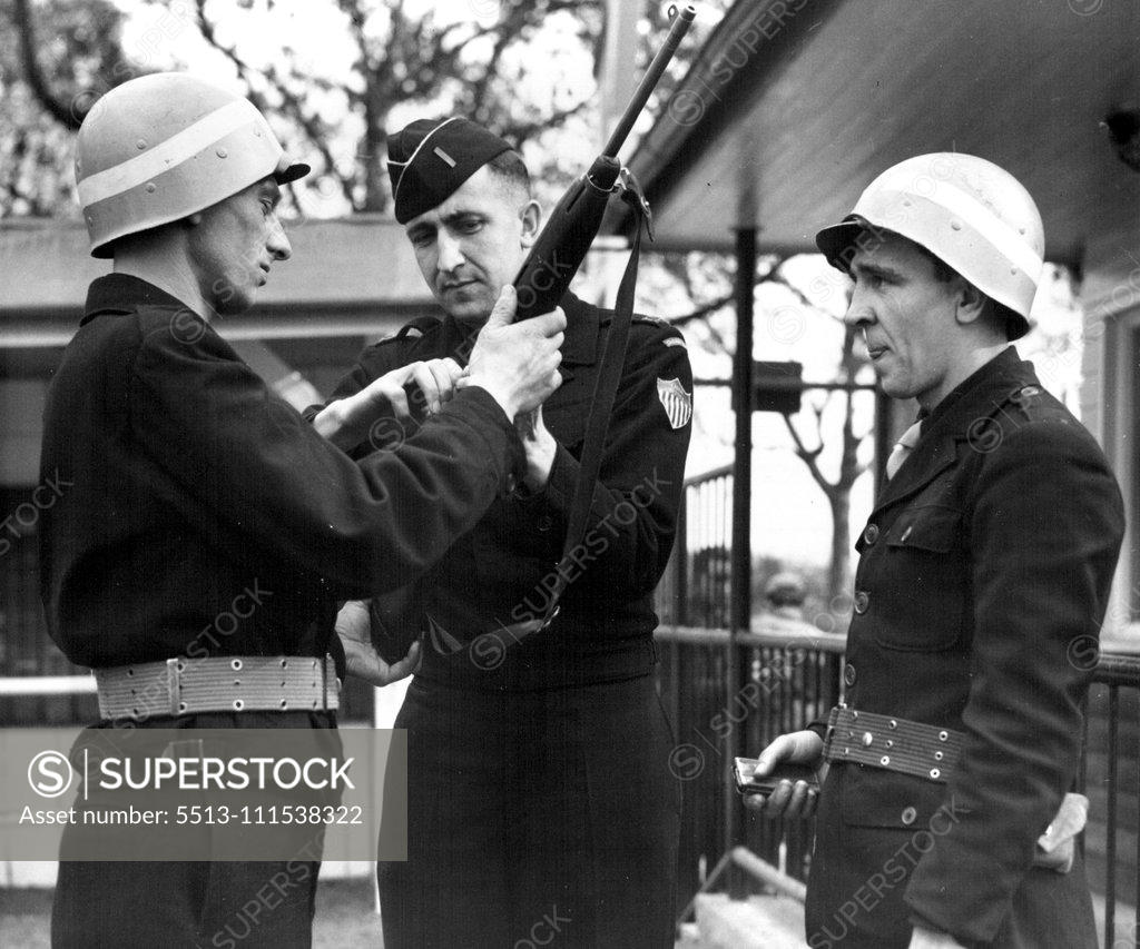 Stock Photo: 5513-111538322 German G.I.'s (Third of Six) - Inspection time at a labor service unit barracks finds a German first Lieutenant (center) checking the rifle of a German guard under his command. November 3, 1950. (Photo by ACME).