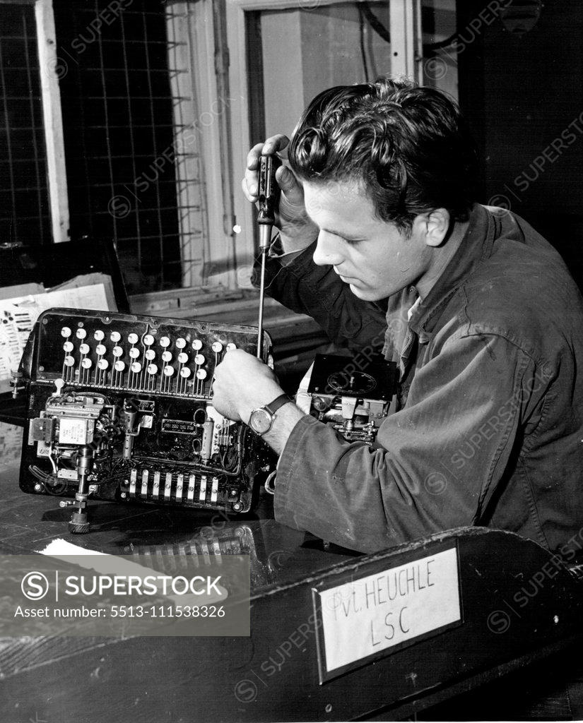 Stock Photo: 5513-111538326 German G.I.'s (Sixth - End of Set) - Repair and maintenance work is one of many necessary duties assigned to labor service unit workers. Private Heuchle, a young German civilian, repairs a teletype machine at a U.S. Signal Depot in Germany. November 3, 1950. (Photo by ACME).