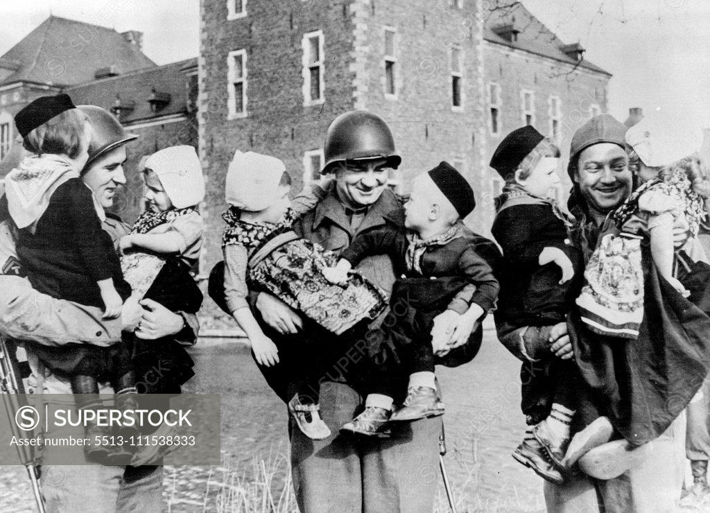 Stock Photo: 5513-111538333 Dutch Kiddies Entertain G.I.s in Famous Castle: Three G.I.s are seen holding their tiny Dutch entertains. They are left to right - T/5 Walter Ward of Newark, New Jersey; T/4 Thomas McMorrow of Brooklyn, N.Y. and T/5 James Firman of Delaware, Ohio. The beautifully moated famous Hoensbrook Castle, Holland, now houses 145 Dutch children, who are cared for by Roman Catholic nuns. G.I.s stationed in the area are very fond of these tiny kiddies (only three years old), and they assist the nuns by takin
