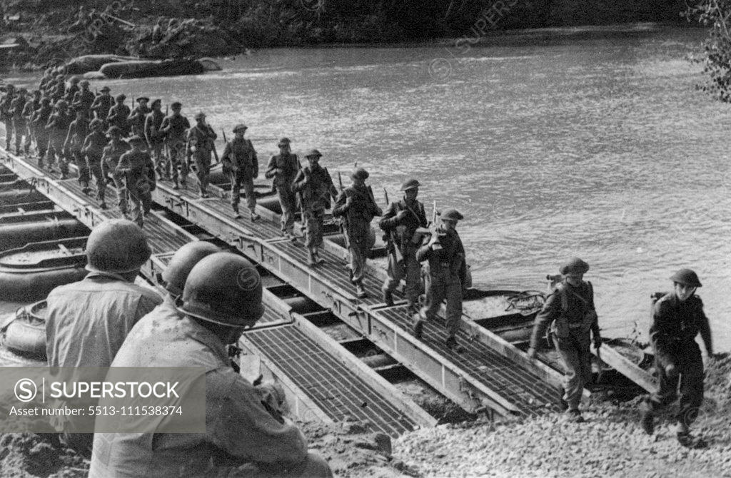 Stock Photo: 5513-111538374 Crossing the River Volturno: Three American engineers watch British troops and transport crossing a Volturno Bridge. On October 13th, 1943, under cover of darkness the Fifth Army made its big assault on the River Volturno, one of the major barriers to advance on Rome - and crossed in force. October 31, 1943. (Photo by Fox Photos).