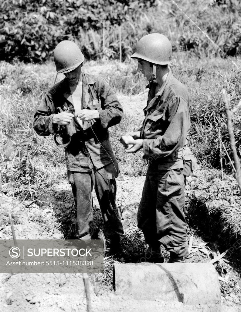 Stock Photo: 5513-111538398 They Make A Jap Mine Innocuous - A heavy Jap mine, left ***** bridge to delay advance of the 1st Cavalry troops upon town of Infanta, Luzon Island, is prepared for destruction by soldiers who moved the mine away from bridge. Here the two soldiers - ***** Route 3, Monkers, Ohio, and John Fadorsen, ***** set booster charge to detonate the mine. May 31, 1945. (Photo by US Signal Corps.).